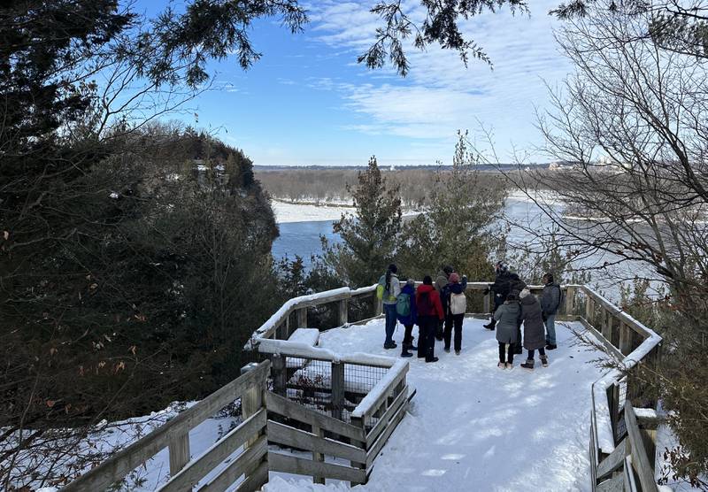 A group of visitors stand on top of Lovers Leap overlooking the Illinois River on Sunday, Jan. 21, 2024 at Starved Rock State Park.