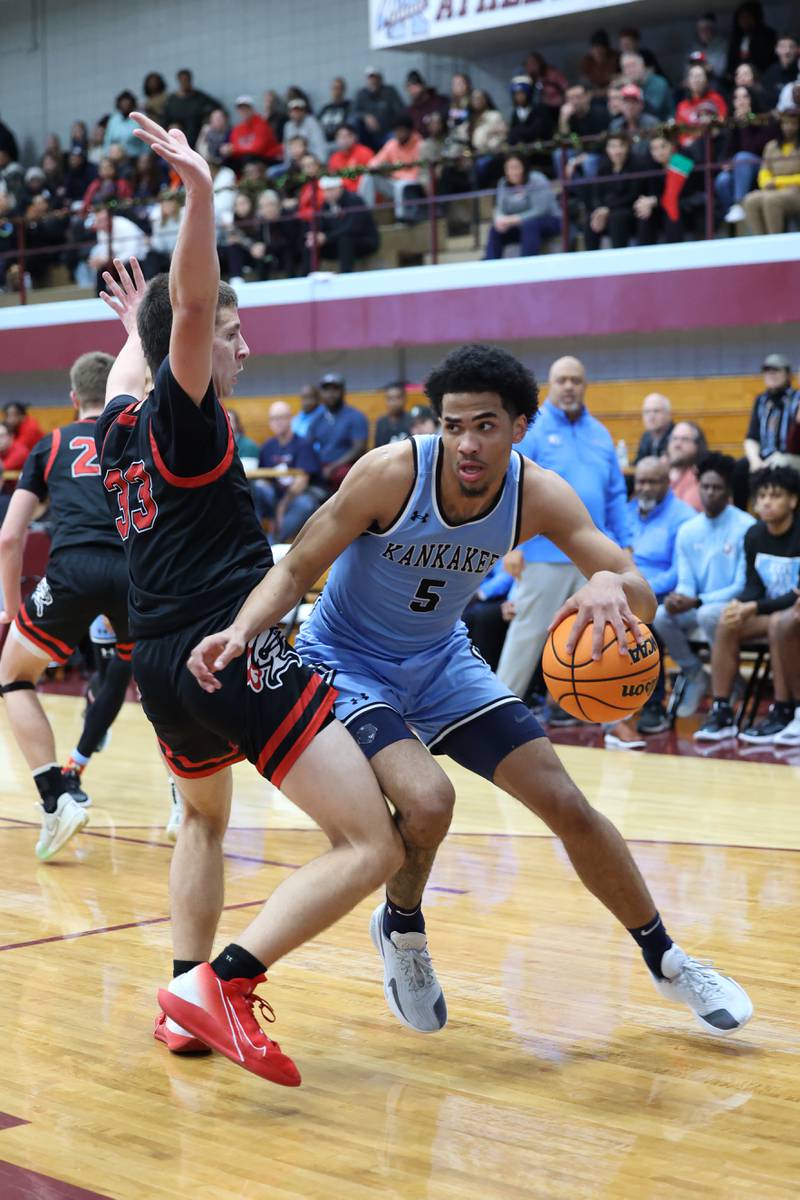 Kankakee's EJ Hazelett looks for pass options as he drives toward the lane during the Kays' 54-50 victory over Lincoln-Way Central in the 75th Kankakee Holiday Tournament maroon bracket championship on Sunday, Dec. 28, 2025.