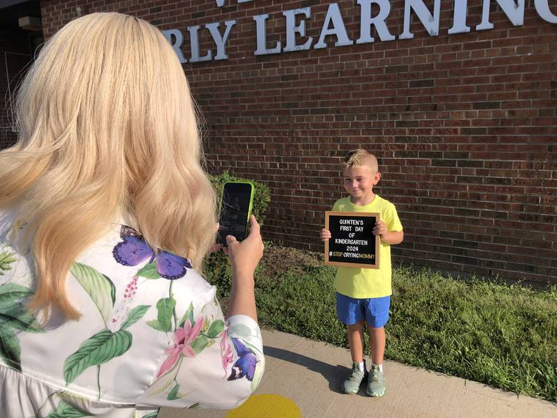 Colleen O'Keefe takes a photo of Quinten Rohlwing, 6, of Woodstock in front of Verda Dierzen Early Learning Center Aug. 14, 2024.