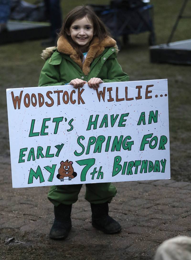 Rosalina Pace, 7, holds her sign as she waits to get a close up look of Woodstock Willie on her birthday on Friday, Feb. 2, 2024, during the annual Groundhog Day Prognostication on the Woodstock Square.