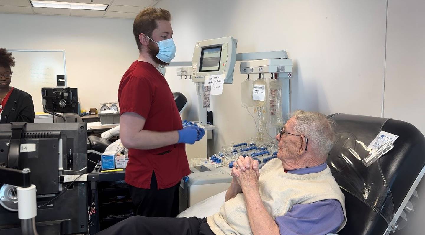 George Murphy, Red Cross phlebotomist, chats with Al Whitney of Ohio when he stopped by the Red Cross office in Romeoville on Tuesday to donate platelets as part of his "Platelets Across America" mission. The Romeoville office is a temporary site for donating platelets.