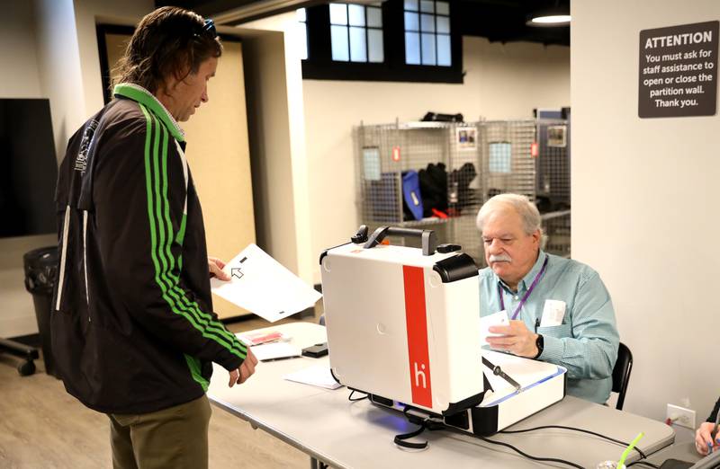 Brian Ahern of St. Charles is assisted by election judge Stan Korwin before voting in the 2025 Consolidated Election on Tuesday, April 1, 2025 at the Baker Community Center in St. Charles.