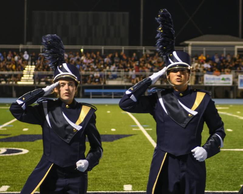 Lemont drum major Eva Casenzo, left, and Luke Rupert salute the crowd after Lemant marching band was named best percussion, best general effect and first place in the AA division of the Downers Grove South Marching Mustangs Music Bowl on Saturday Oct. 5, 2024, held at Downers Grove South High School football field.