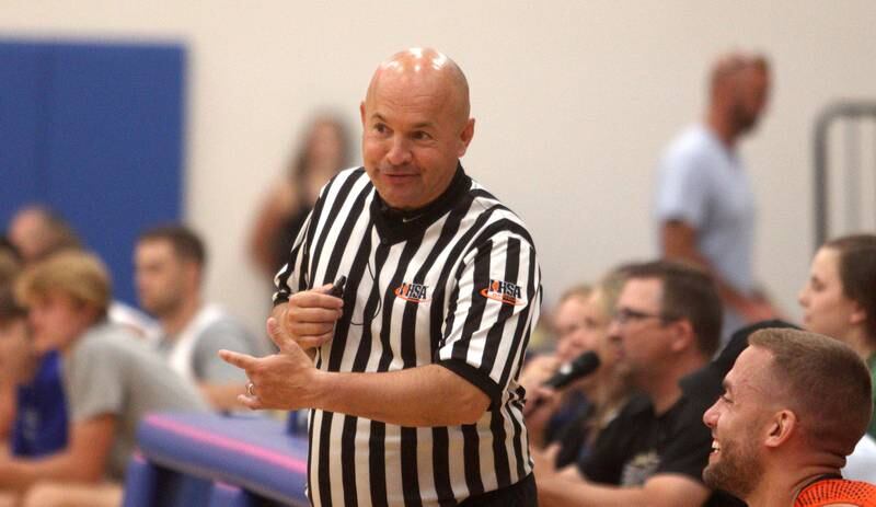 Referee Jason Chupich shares a laugh with players on the McHenry bench during an alumni basketball game at Johnsburg High School Saturday evening to benefit the family of Jackson Werderitch, a 10-year-old who was struck by a car.