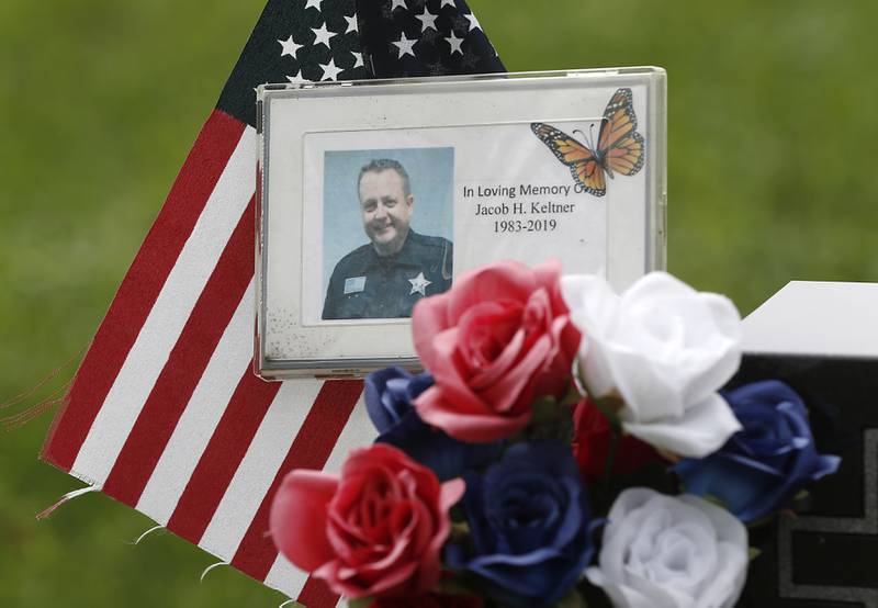 A detail of items left at the headstone for McHenry County sheriff’s Deputy Jacob Keltner, on Monday, Aug. 29, 2022, in Crystal Lake Memorial Park, 8012 Ridgefield Road in Crystal Lake. Keltner was killed in the line of duty while serving an arrest warrant in Rockford in March 2019.