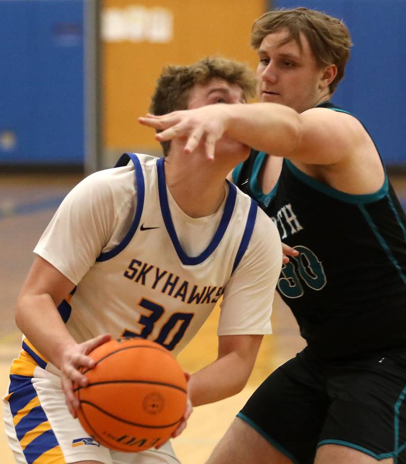 Johnsburg's Jayce Schmitt drives to the basket against Woodstock North's Brady Rogers during a Kishwaukee River Conference boys basketball game on Monday, Dec. 15, 2025, at Johnsburg High School.