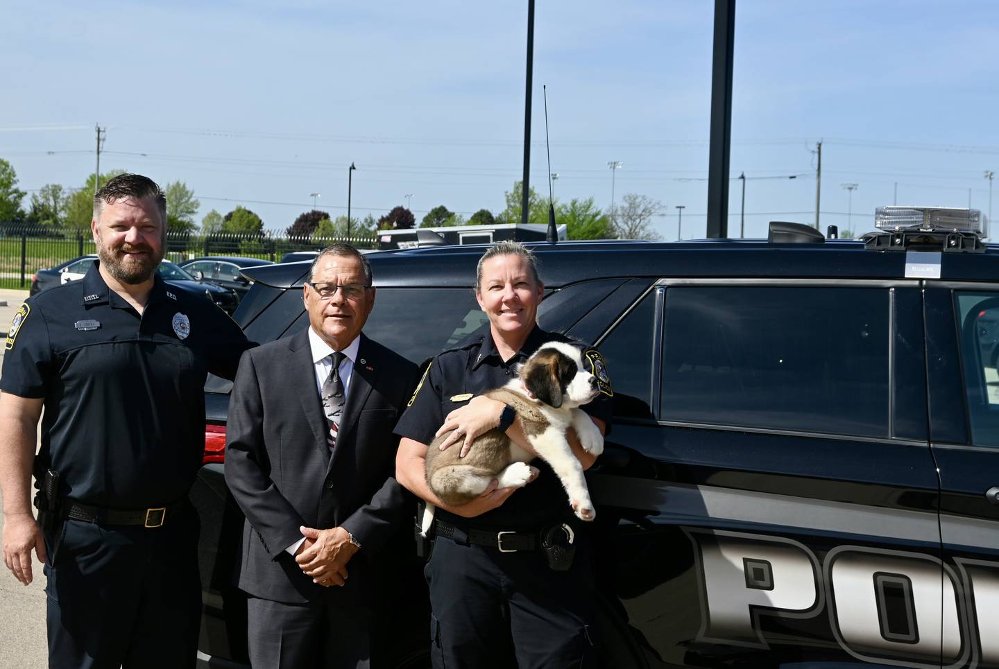 School Resource Officer Brian Zebron with La Salle State's Attorney Joe Navarro and Peru Police Chief Sarah Raymond holding Peru's newest recruit Haven.