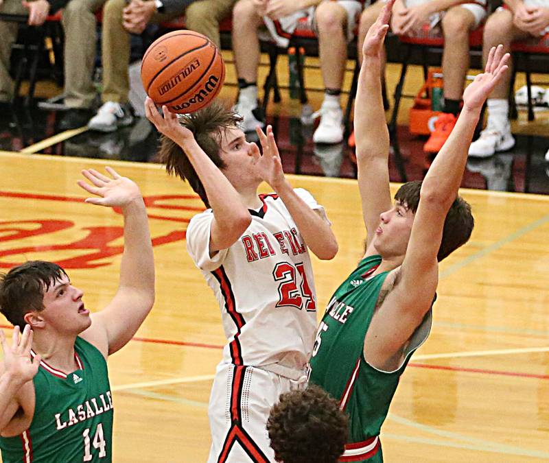 Hall's Kyian Smith (24) cuts in the lane between L-P's Nolan Van Duzer (14) and teammate Brendan Boudreau (45) on Tuesday, Nov. 29, 2022 at Hall High School in Spring Valley.
