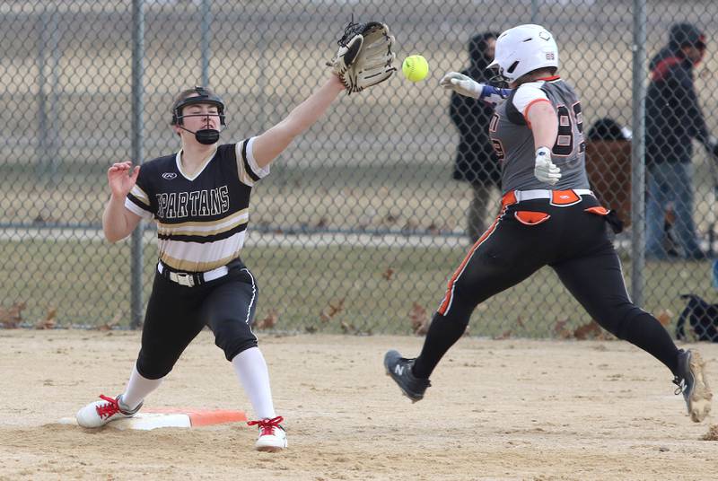 Sycamore first baseman Brooklynn Snodgrass stretches for the throw as a Harlem baserunner hustles to the bag during their game Friday, March 25, 2022, at the Sycamore Community Sports Complex.