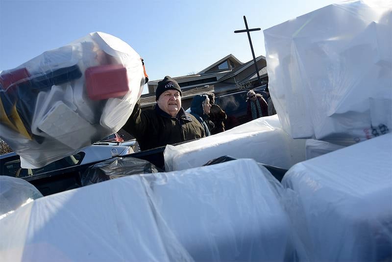 Earth Care Team member Ken Mozingo tosses a bag of Styrofoam into the back of a pickup truck during the Oswego Presbyterian Church's 2018 polystyrene-Styrofoam recycling event.