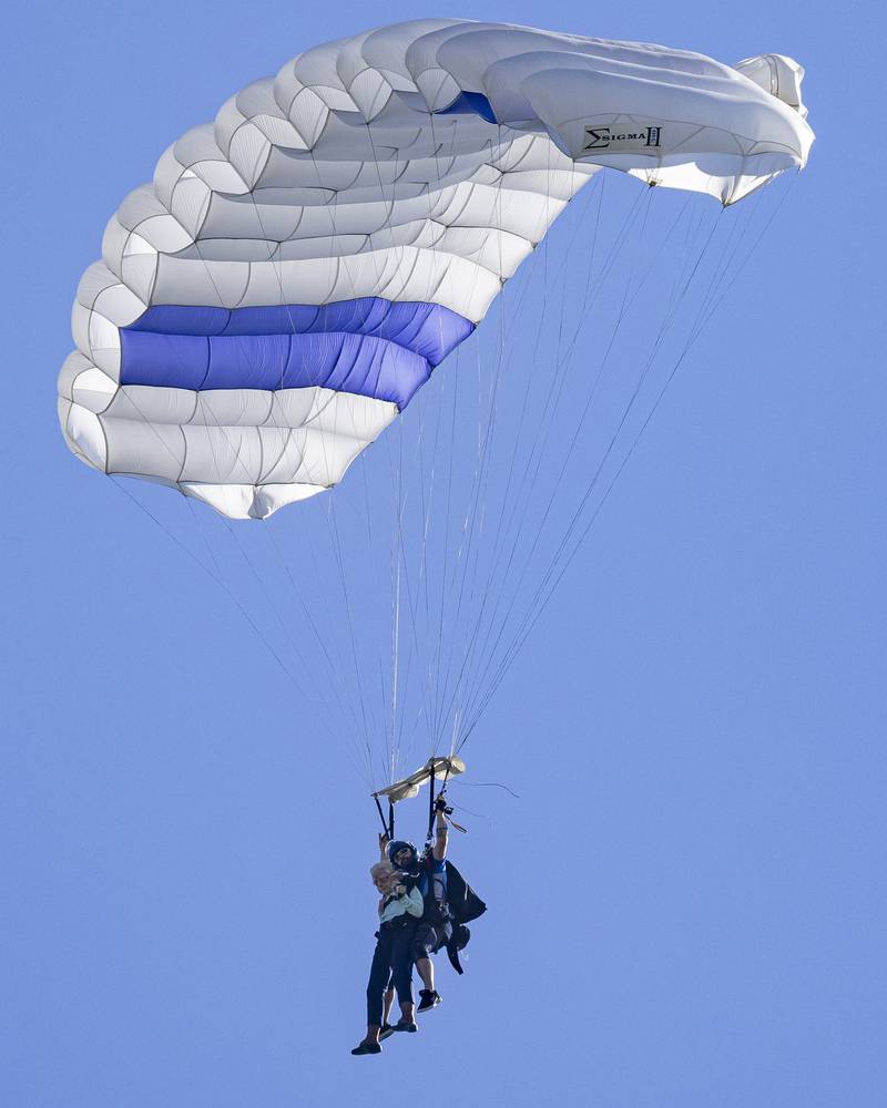 Dorothy Hoffner and her tandem instructor Baxter sail smoothly back to the ground under parachute at Skydive Chicago on October 1, 2023.