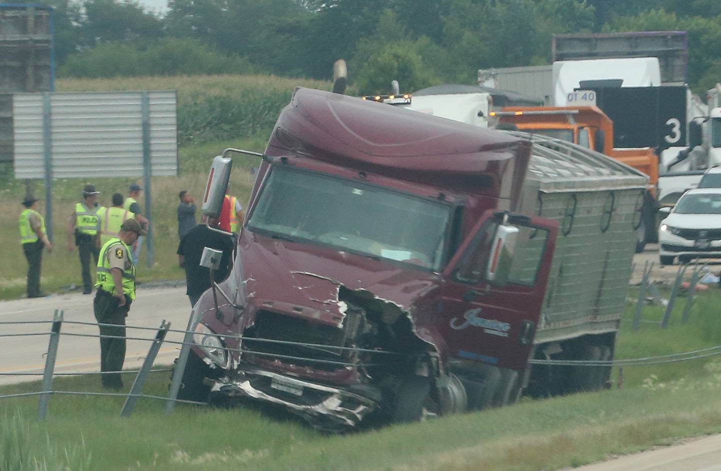 An Illinois State trooper inspects a damaged semi tractor trailer that was involved in a multiple vehicle crash a mile east of the Route 71 and Interstate 80 interchange on Wednesday, Aug. 2, 2023, near Ottawa.