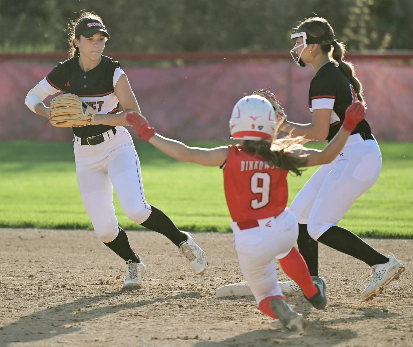 Naperville Central’s Mae Binkowski is forced out at second by Benet Academy shortstop Ester Lynn Rossi in a softball game in Lisle on Thursday, Apr. 16, 2026.