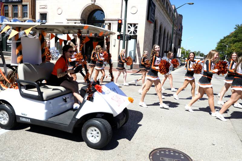 St. Charles East dance team team members walk in the school’s homecoming parade on Main Street through Downtown St. Charles on Thursday, Aug. 31, 2023.