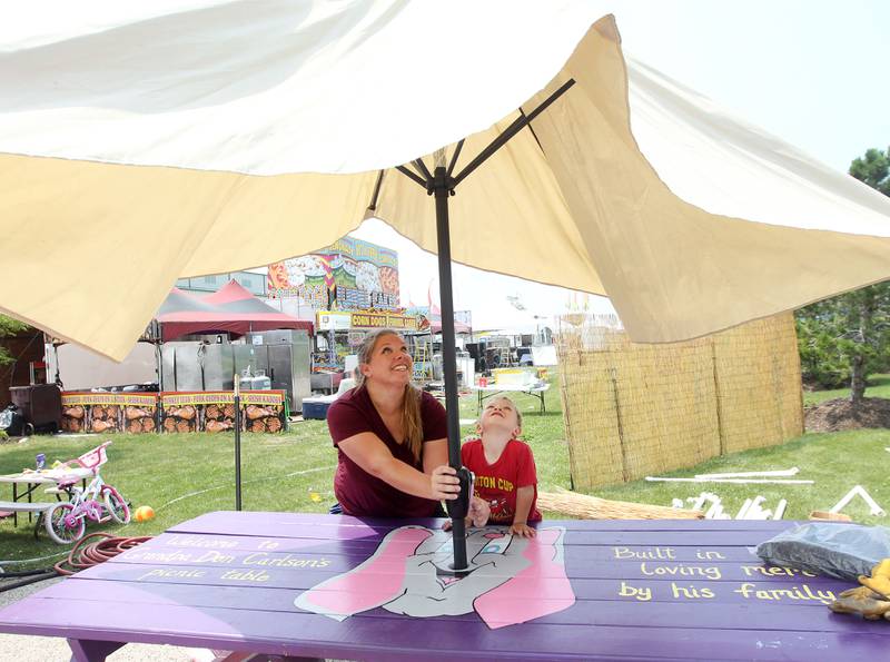 Mandy Modriaga, of Capron, owner, with Parnell Foods, and her son Alex, 3, put up an umbrella for a picnic table next to their Elephant Ears food truck as they get ready for the start of the Lake County Fair on Tuesday, July 25th at the Lake County Fairgrounds in Grayslake. The fair runs from July 26th-30th.
Image by Candace H. Johnson for Shaw Local News Network