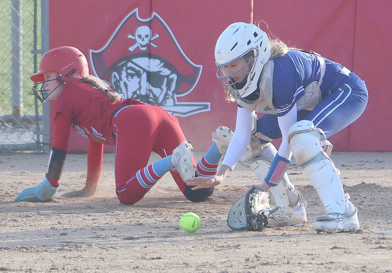 Ottawa's Rylee Harsted crosses safely into home as Princeton catcher Kiyrra grabs the late throw on Friday, March 13, 2026 at Ottawa High School.