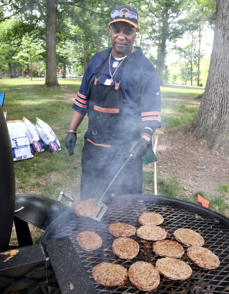Meldon Macon Sr. cooks burgers in the food area during the Juneteenth Community Celebration Saturday, June 15, 2024, at Hopkins Park in DeKalb.