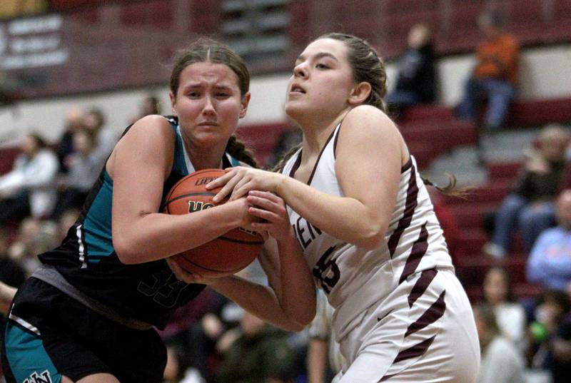 Marengo’s Emilie Polizzi, right, battles Woodstock North’s Adelynn Saunders in varsity girls basketball at Marengo Tuesday evening.