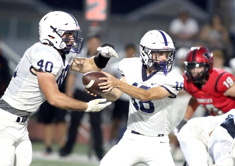 Cary-Grove’s quarterback Shane Coyle, right, hands off to Logan Abrams in varsity football at Huntley High School in Huntley on Friday, Sept. 19, 2025.
