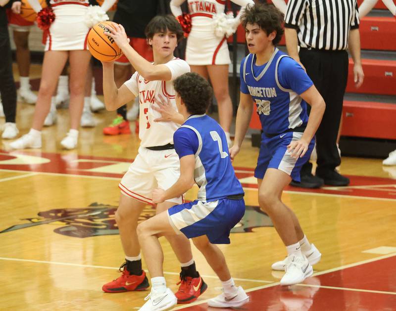 Ottawa's Aleixo Fernandez looks to pass the ball over Princeton's Stihl Brokaw during the Dean Riley Shootin' The Rock Thanksgiving Tournament on Monday Nov. 24, 2025 in Kingman Gymnasium at Ottawa High School.