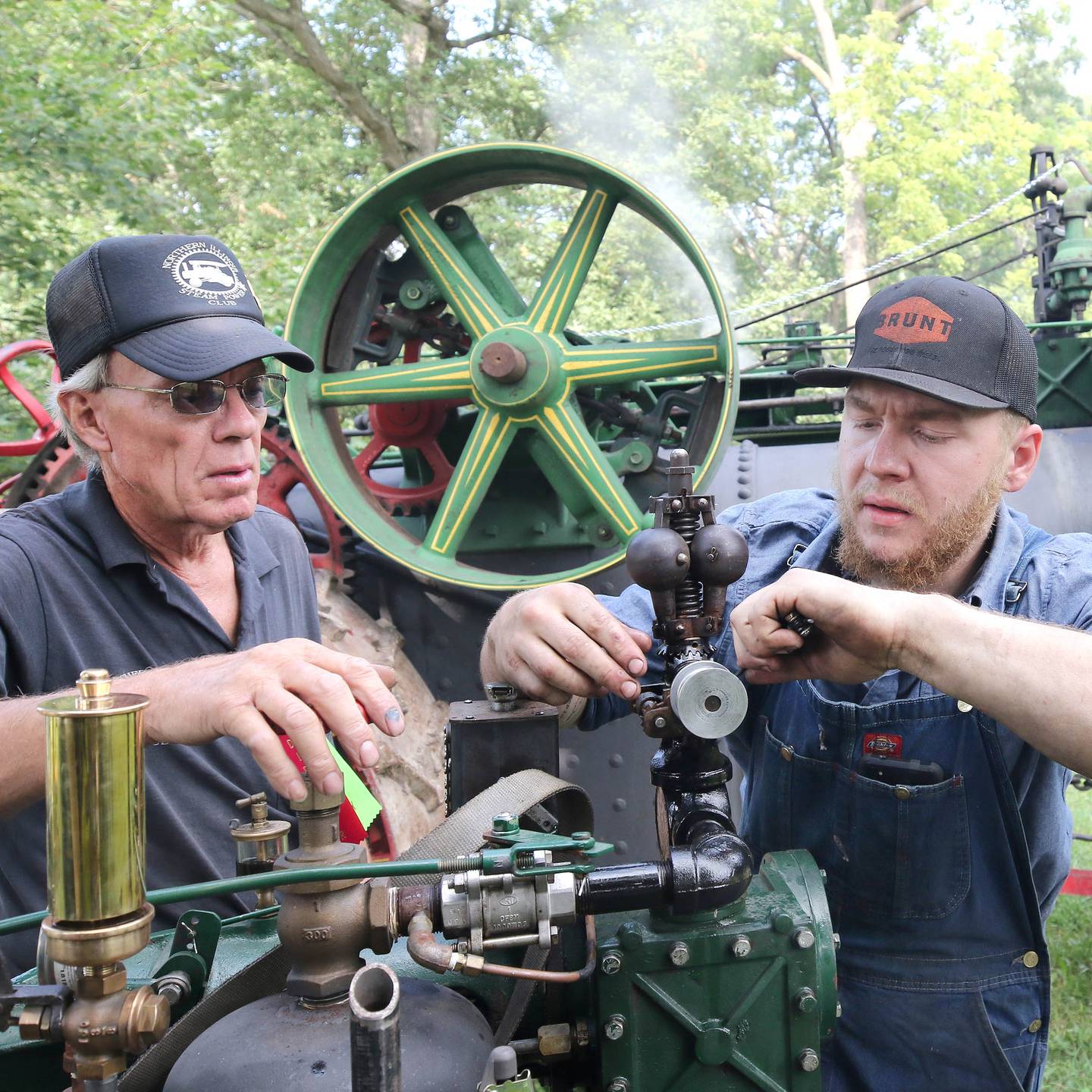 Dave Stevens, (left) from Sycamore, and Jack Stuffle, from Hinckley, work on a half-scale 65 horsepower Case steam tractor during the Sycamore Steam Show Thursday, Aug. 10, 2023, at Taylor Marshall Farm in Sycamore. The show runs from 7 a.m. to 5 p.m. through Sunday.