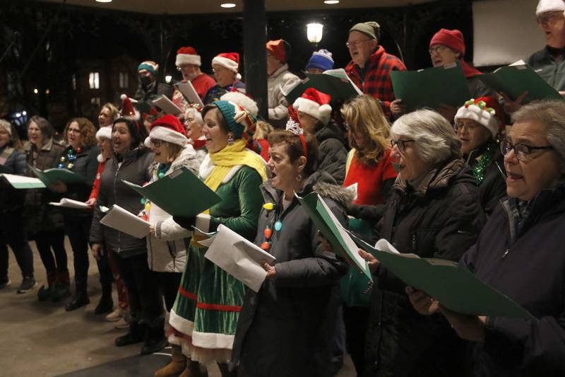 Members of the Woodstock Community Choir sing Christmas carols during the Lighting of the Square Friday, Nov. 25, 2022, in Woodstock. The annual event featured brass music, caroling, free doughnuts and cider, food trucks, festive selfie stations and shopping.