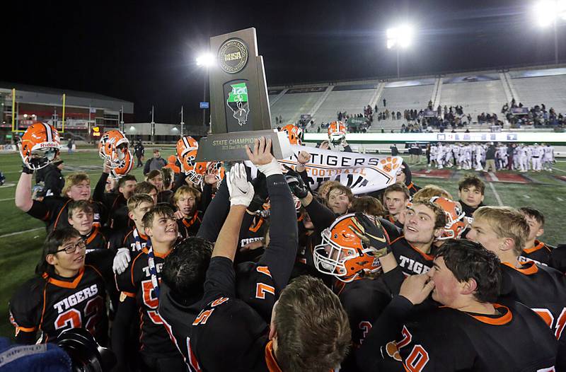 Members of the Byron football team hoist the Class 3A trophy after defeating Tolono, 35-7, at Huskie Stadium on Friday Nov. 26, 2021 in DeKalb.
