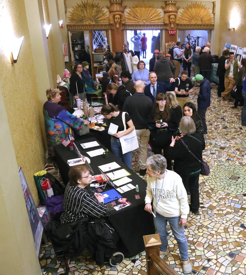 Visitors check out some of the tables Thursday, April 18, 2024, during Earth Fest at the Egyptian Theatre in DeKalb. The event, in honor of Earth Week, was presented by DeCarbon DeKalb, in partnership with NIU.