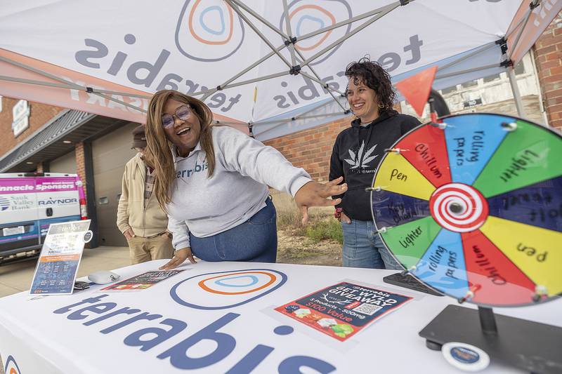 Terrabis representatives Brandon Winters (left), Dottie Davis and Carissa Murawski offer spins of a wheel for free swag Saturday, Sept. 6, 2025, at Dement Town Music Fest.