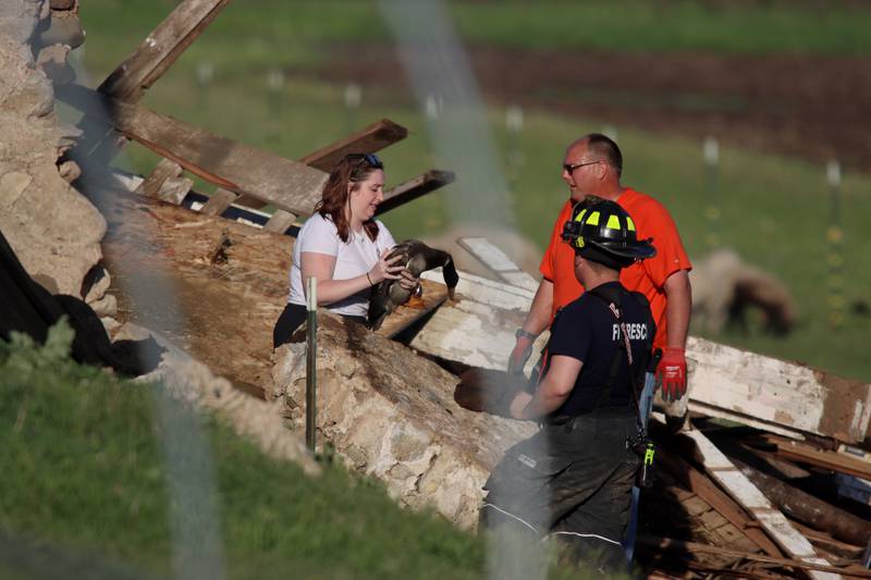 First responders and property owners tend the scene of a barn collapse along Weidner Road near Harvard on Tuesday evening.