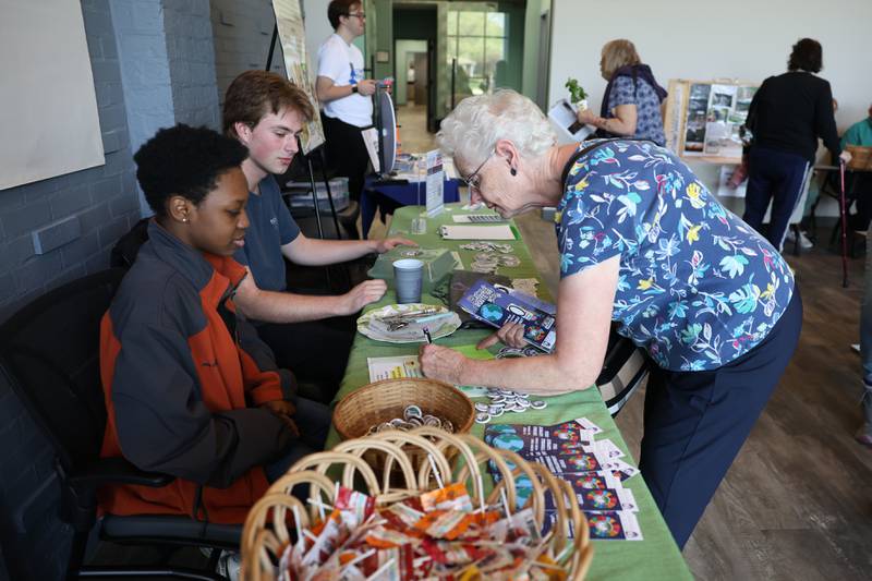 Rita Renwick files out a card at the Joliet Junior College table at the Green Escape Earth Day Event on Wednesday, April 22, 2026 in Joliet.
