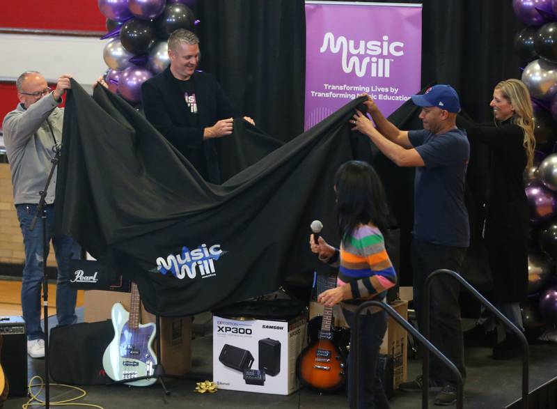Tom Morello, (right) unveils musical instruments that were donated to Marseilles Elementary School through Music Will, the largest nonprofit music program in the United States public school system at Marseilles Elementary School on Thursday, Nov. 30, 2023.