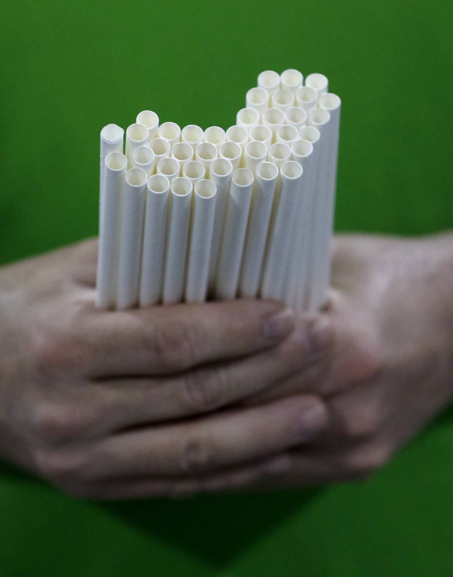 Andy Spinelli , of Boss Straw, holds paper straws made by the company on Wednesday, March 12, 2025, in Woodstock The company manufactures paper straws and has been hit hard by the federal government switching back to plastic straws.