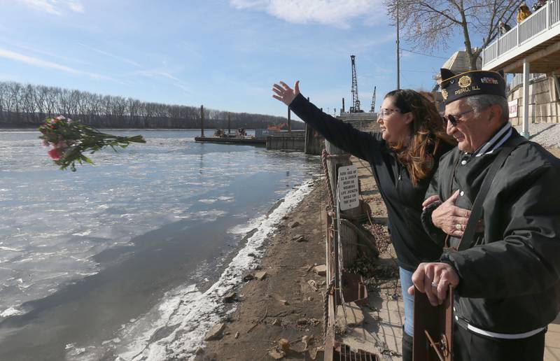 Christa Hammers Superintendent of the LaSalle County Vetarans Assistant Commission, tosses a memorial bouquet into the Illinois River as Veteran Phil Valle escorts her to the water during the annual Pearl Harbor parade and memorial service on Saturday in Peru. This year marks the 83rd anniversary of the Dec. 7, 1941, attack on Pearl Harbor.