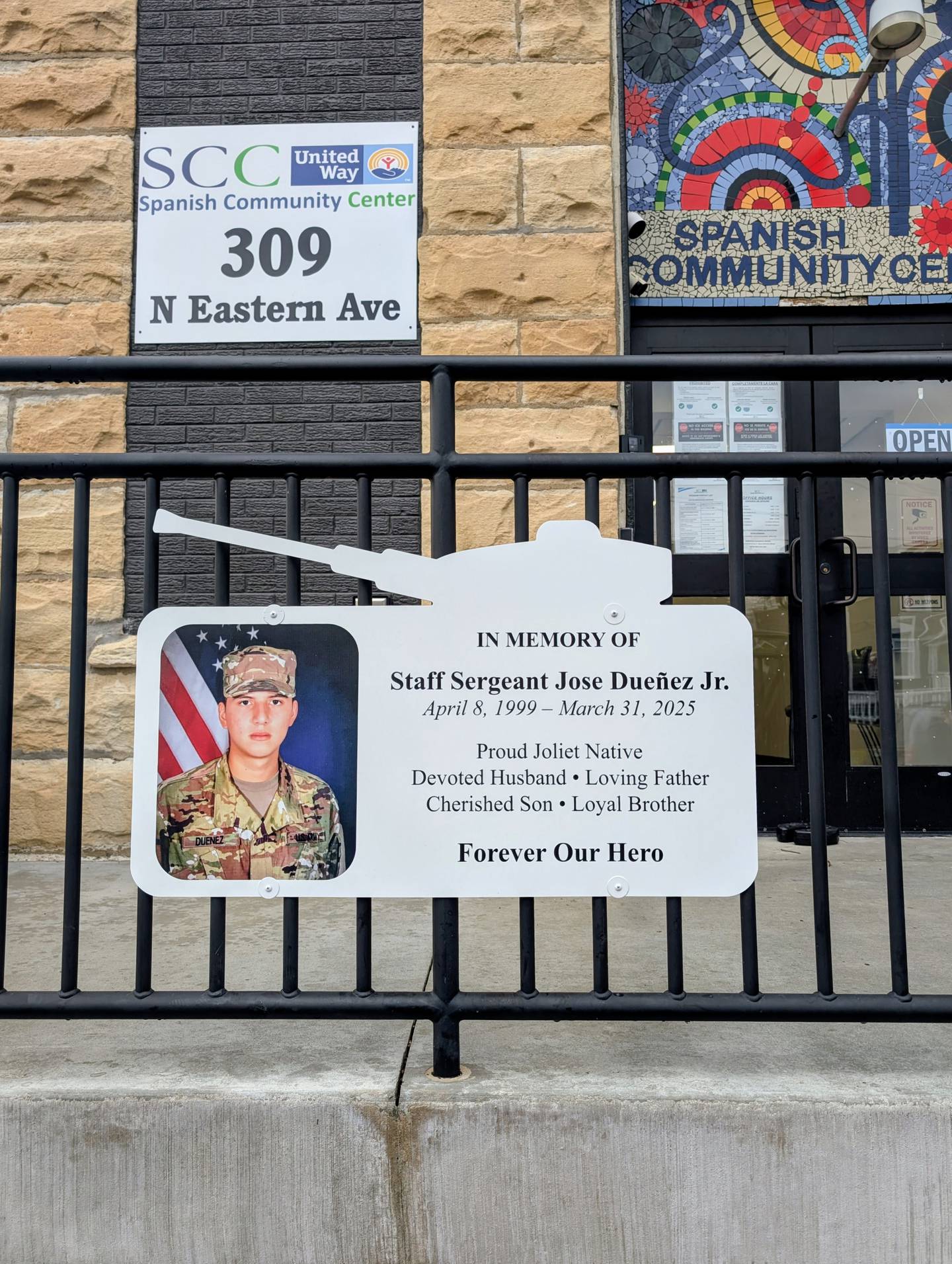 A sign honoring the late Staff Sgt. Jose Duenez Jr. is posted outside the front entrance to the Spanish Community Center in Joliet. March 31, 2026