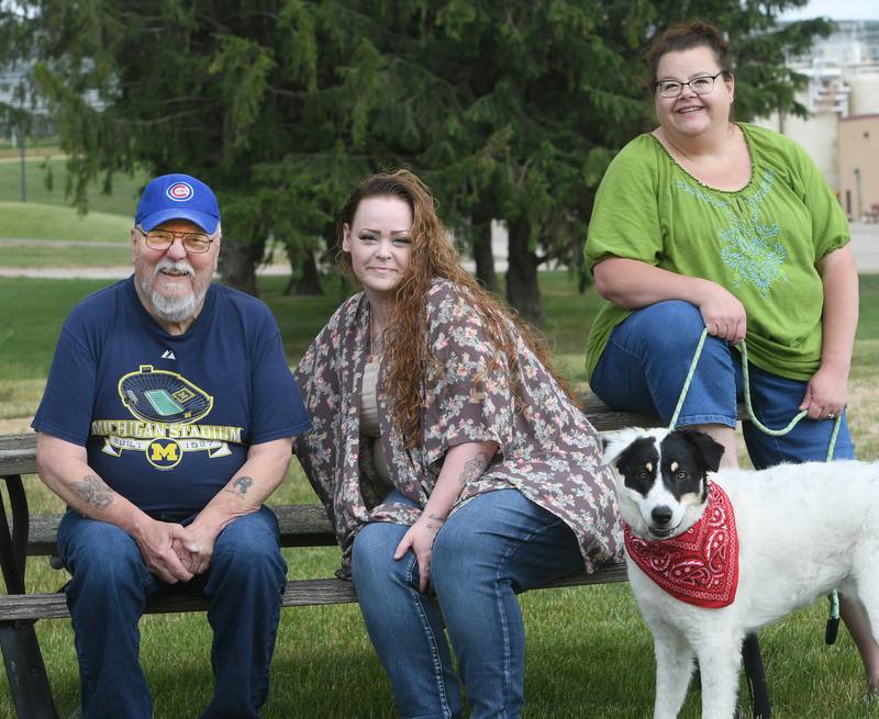 Jennifer McMullan (center) sits with her dad, Ron Johnson, and sister Amanda Carlson and Amanda's dog Jasper on Saturday, June 26, 2021, near Carlson's home in a far northwest Illinois town.