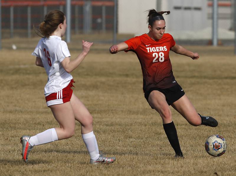 Crystal Lake Central's Jillian Mueller, right takes a shot on goal as she is guarded by Marian Central's Greta Fortin during a non-conference soccer match Monday, March 21, 2022, between Crystal Lake Central and Marian Central at Crystal Lake Central High School.