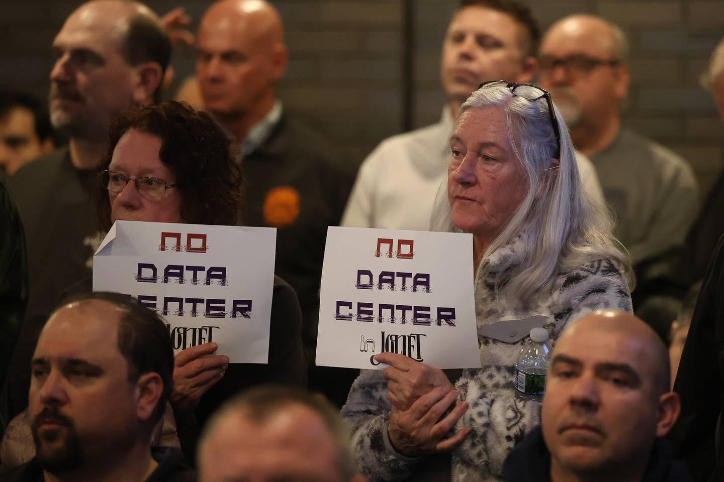 Residents holds signs against the proposed Data Center at the City of Joliet Plan Commission meeting on Thursday, March 5, 2026 in Joliet.