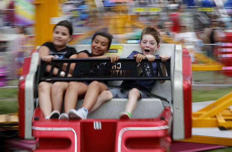 Caitlyn Wiede, 10, Kylee Romanyk, 9, and Ewan Gulbranden, 7, ride on the Sizzler ride during Lakeside Festival on Friday, July 5, 2024, at the Dole.