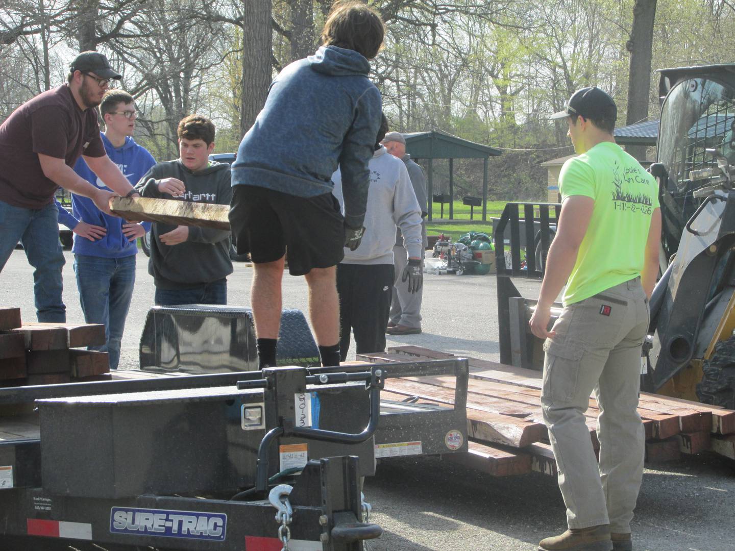 Streator High School woodworking students in David Taylor's class set up an assembly line to pass wooden beams to load onto a forklift Wednesday, April 19, 2023, as they begin to construct a picnic shelter at Marilla Park in Streator.