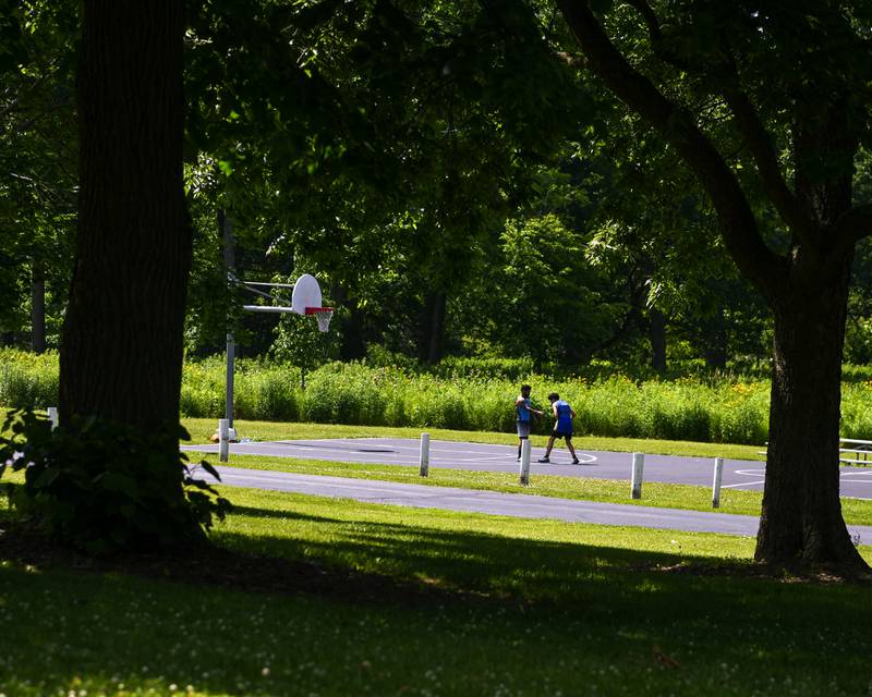 Ezequiel Cruz, 13, (right) and his dad David Cruz of DeKalb play some basketball during the annual Juneteenth Community Celebration on Sunday, June 22, 2025, at Hopkins Park in DeKalb.