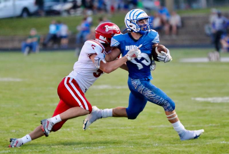 Princeton's Augie Christiansen has some company in red on his run against Hall Friday night at Bryant Field.