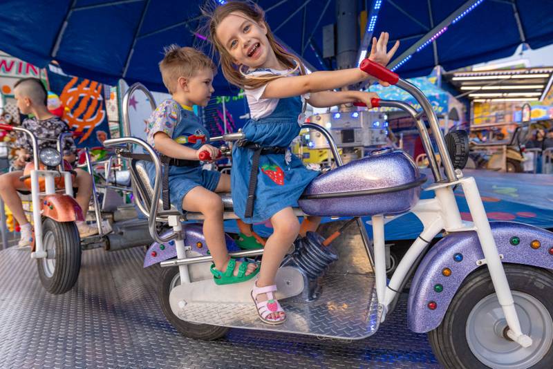 Nora Nolley and her brother Paul ride the motorcycle merry go round at Streator Fest on August 1, 2025.