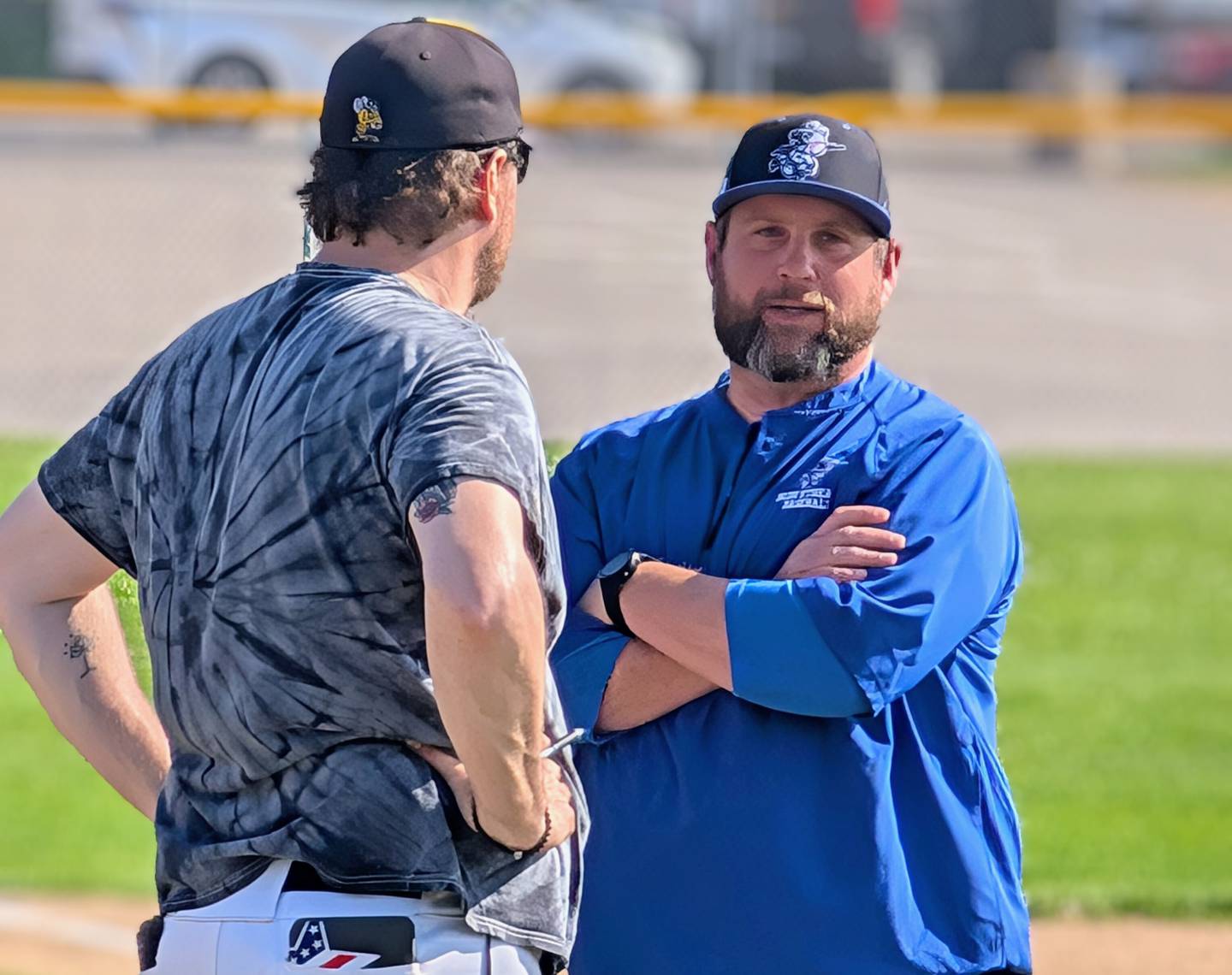Woodstock baseball coach Ian Rago (right) talks to Harvard coach Adam Ulen during their teams' Kishwaukee River Conference game Tuesday, May 13, 2025, in Harvard.