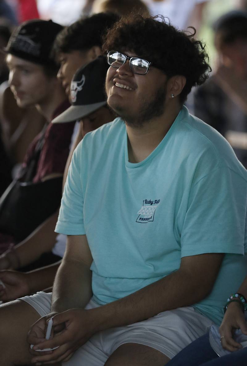 Edgar Puga smiles as he listens to a story during a candlelight celebration for Riely Teuerle on Thursday, August 11, 2022, at Towne Park, 100 Jefferson Street in Algonquin. Teuerle was killed in a car crash in Lake in the Hills on Tuesday. Over 100 family members and friends gathered at the park to remember and celebrate Teuerle’s life.