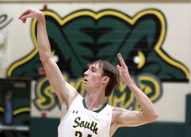 Crystal Lake South’s James Carlson puts the finishing touch on a three pointer against Woodstock North in varsity basketball at Crystal Lake Saturday afternoon.