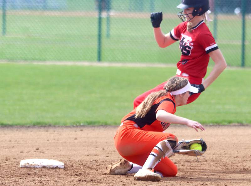St. Charles East’s Abby Arend, front, fields the throw as Huntley’s Jori Heard tiptoes in safely at second base during varsity softball at Marengo Saturday morning.