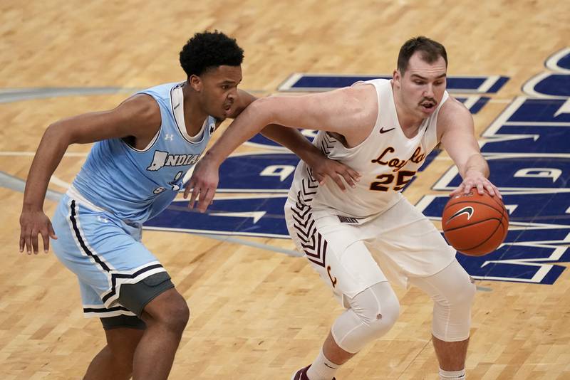 Loyola of Chicago's Cameron Krutwig, right, dribbles as Indiana State's Tre Williams defends during the second half of an NCAA college basketball game in the semifinal round of the Missouri Valley Conference men's tournament Saturday, March 6, 2021, in St. Louis. (AP Photo/Jeff Roberson)