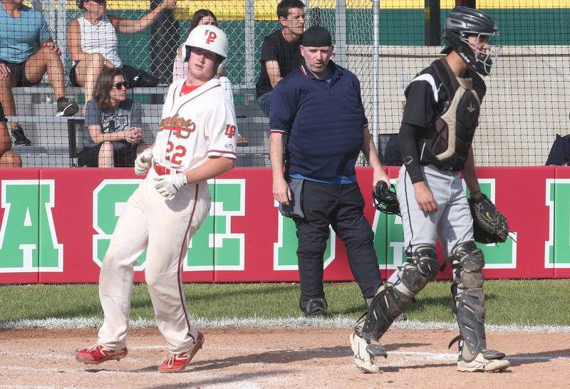 L-P's Ceyton Urbanski crosses home plate while Kaneland catcher Nate Campbell watches the play on Tuesday, May 13, 2025 at Huby Sarver Field at the L-P Athletic Complex in La Salle.