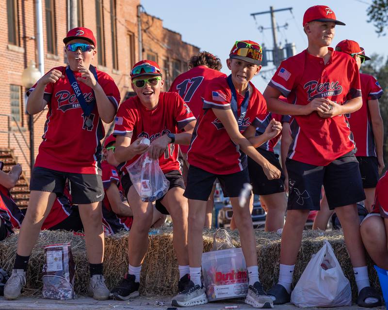 Members of the Peru Parkside baseball team watch as one of the athletes throw a tootsie roll as hard as he can at a friend in the crowd of spectators during the St. Bede homecoming parade on October 3, 2025 in Peru.